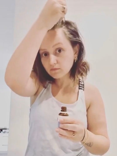 hair oil with rosemary applied on scalp to stimulate hair growth