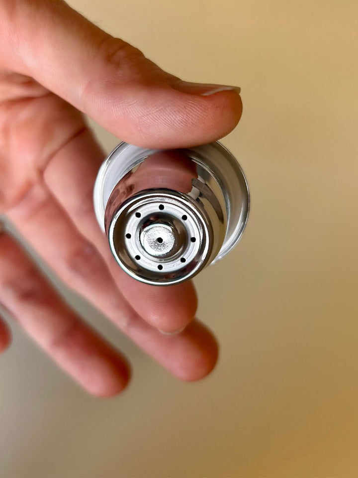 hand holding a reusable stainless steel capsule for nespresso machines