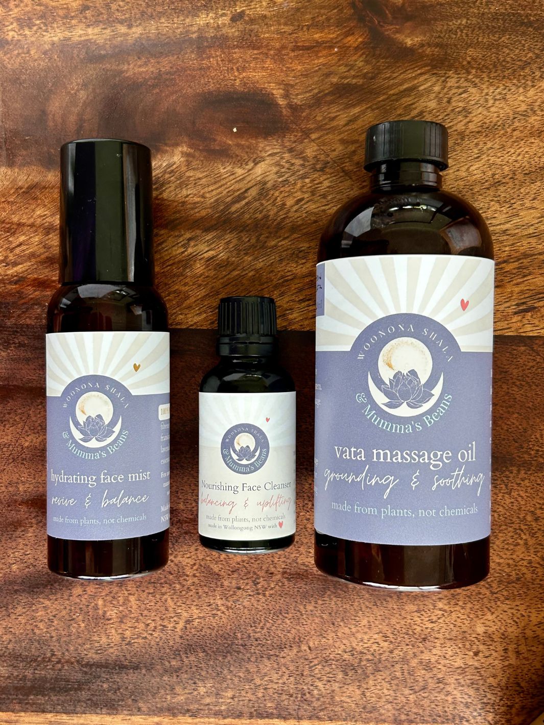 Three bottles of yoga skincare products on a wooden surface